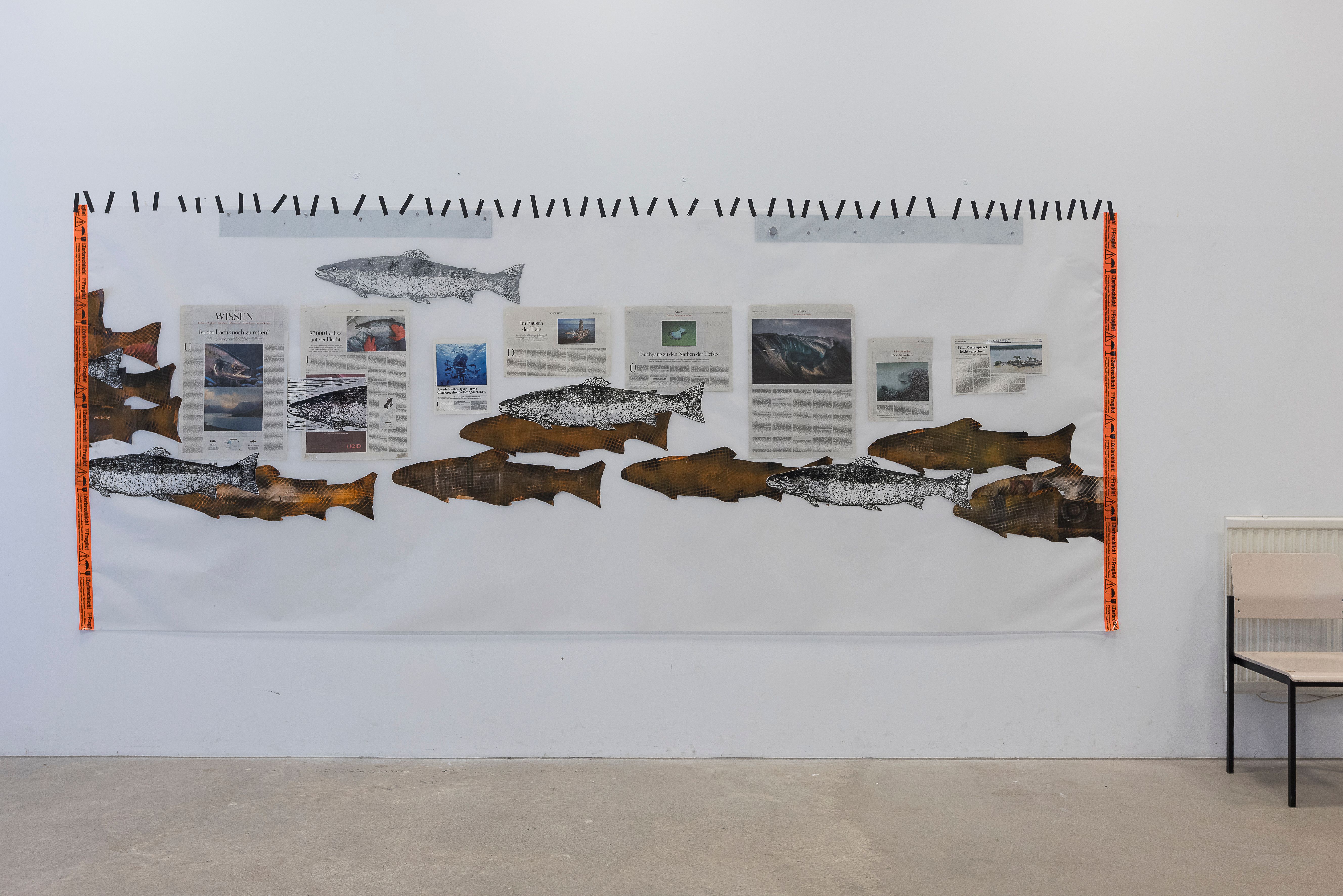 Breite Bildcollage mit Zeichnungen und braunen Papierformen an einer weißen Wand.