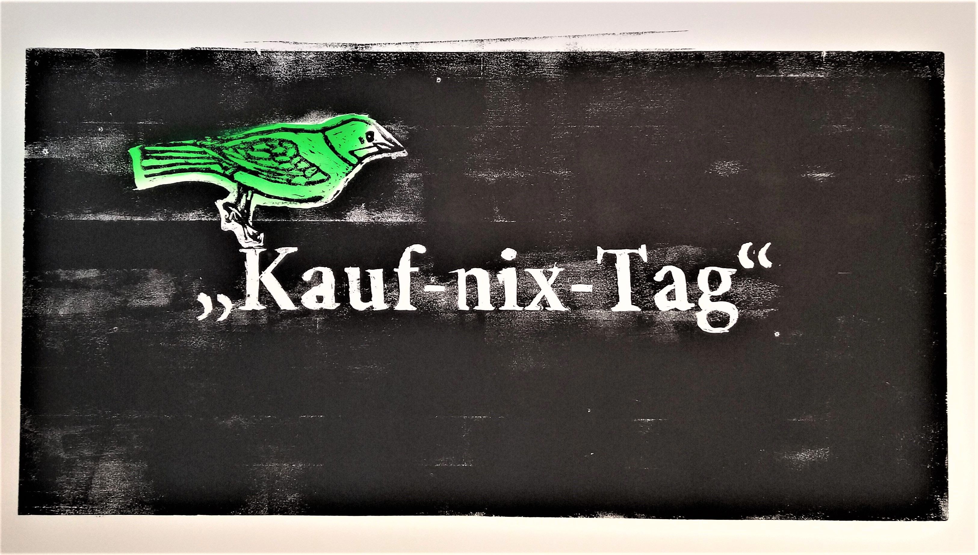 Schwarze Grafik mit grünem Motiv und weißem Schriftzug Kauf-nix-Tag.